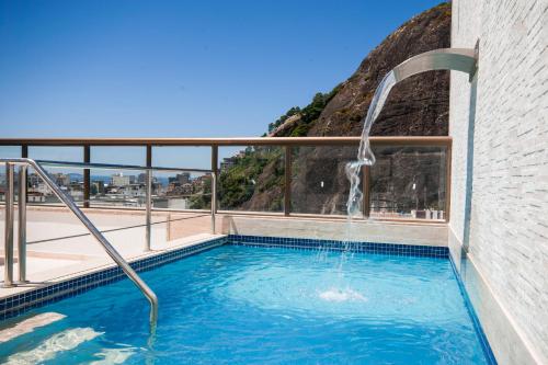 a swimming pool with a water fountain at Hotel Atlântico Rio in Rio de Janeiro