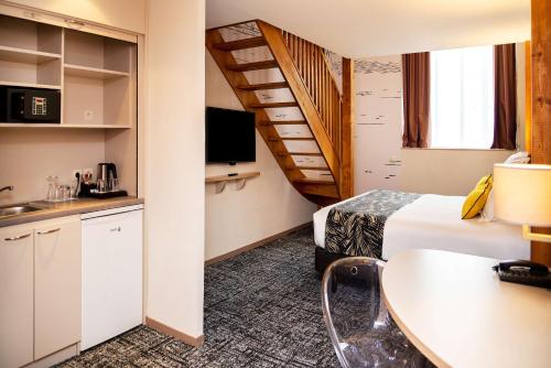 a hotel room with a bed and a staircase at Best Western Plus Hôtel Colbert in Châteauroux