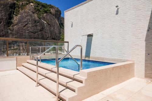 a swimming pool with stairs next to a building at Hotel Atlântico Rio in Rio de Janeiro