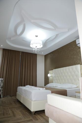 a bedroom with a white bed and a ceiling at METROPOLIS in Ulcinj