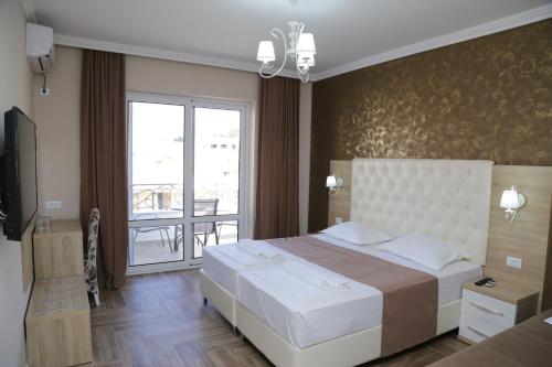 a bedroom with a large bed and a balcony at METROPOLIS in Ulcinj