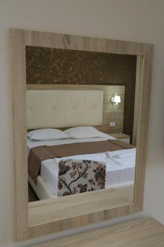 a reflection of a bedroom with a bed in a mirror at METROPOLIS in Ulcinj