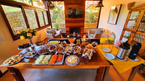 a table with a buffet of food on it at Pousada Paraíso Gaia in Praia do Rosa