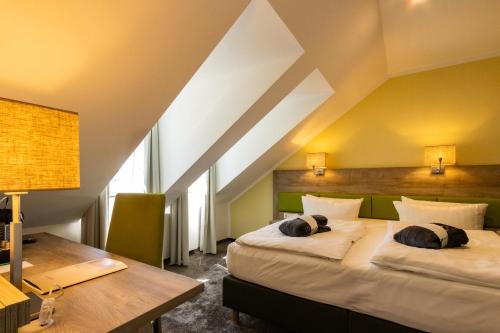 a hotel room with two beds and a desk at BERG & SPA HOTEL GABELBACH in Ilmenau