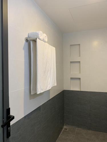 a bathroom with white towels hanging on a wall at Rang Dong Hue Hotel in Hue