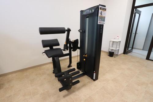a gym with a chair and a machine at Hotel Kanade Kanku Kaizuka in Kaizuka