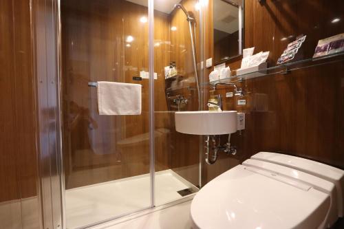 a bathroom with a shower and a toilet and a sink at Hotel Kanade Kanku Kaizuka in Kaizuka