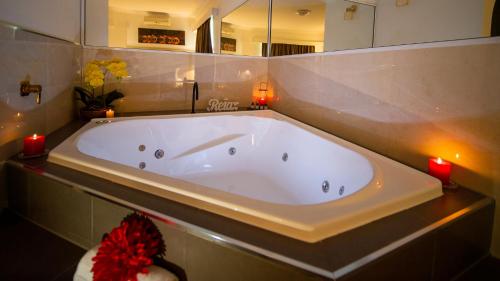 a large white tub in a bathroom with candles at Hamilton's Queanbeyan Motel in Queanbeyan