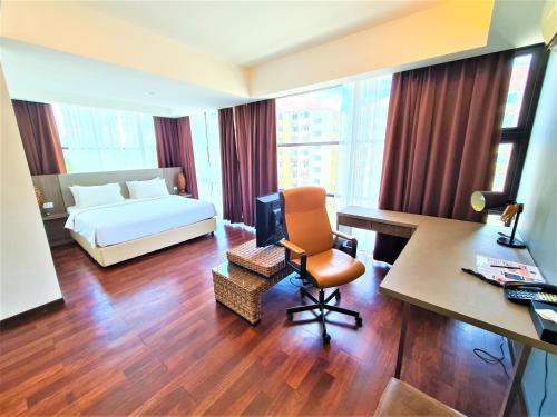 a hotel room with a bed and a desk and a desk at Nexus Regency Suites & Hotel in Subang Jaya