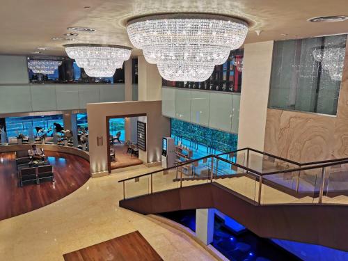 a hotel lobby with a pool and chandeliers at M Hotel Singapore City Centre in Singapore