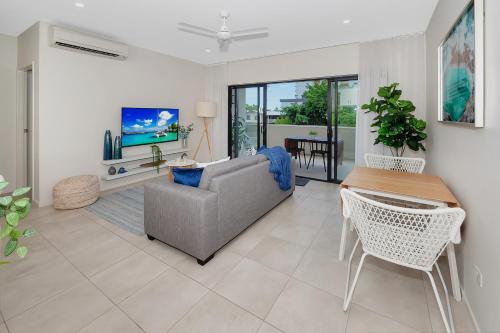 a living room with a couch and a table at Apartment Close to the City Life on Lake 3 in Cairns North