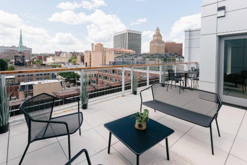 a balcony with chairs and tables and a view of a city at Kislak 303 Luxurious 2BR in Heart of Downtown in Newark