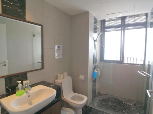 a bathroom with a toilet and a sink and a shower at The Landmark by Comfy in George Town