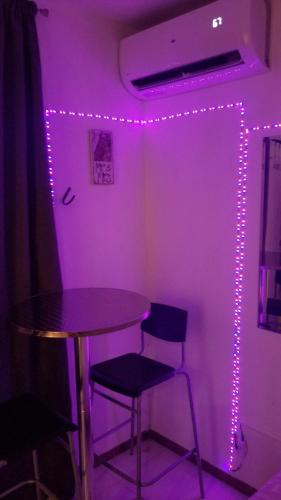 a table and chairs in a room with purple lights at You & Me Tropical Studio in San Juan