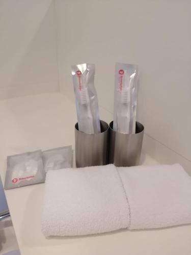 a counter top with two toothbrushes and towels at Travelodge Kowloon in Hong Kong