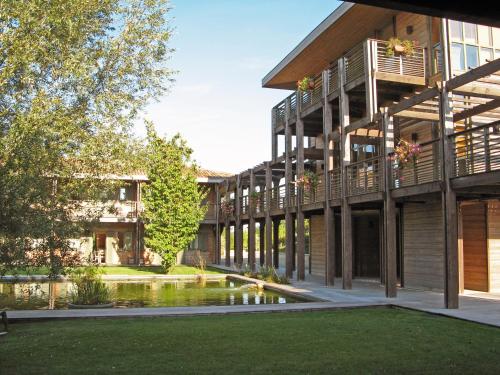 a building with a pond in front of it at Résidence Les Vignes in Jonzac