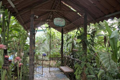 a wooden pergola with a bench in a garden at Salamandra Costa Rica in Jiménez