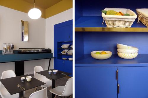 サン・テティエンヌにあるUrban Style, Hôtel Le Cheval Noir, Saint-Étienneの青い壁のダイニングルーム(テーブル、椅子付)