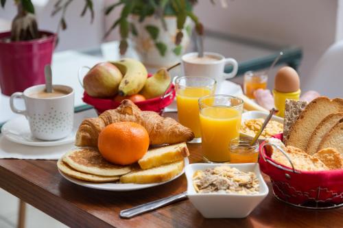 a breakfast table with toast and coffee and orange juice at Urban Style, Hôtel Le Cheval Noir, Saint-Étienne in Saint-Étienne
