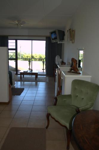 a living room with a couch and a table and a kitchen at Crowned Crane in Gonubie