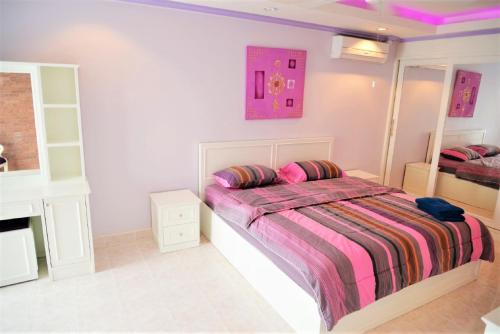 una camera bianca con letto e specchio di Luxury apartment Jomtien beach condominium S1 Pattaya 3rd floor a Jomtien Beach