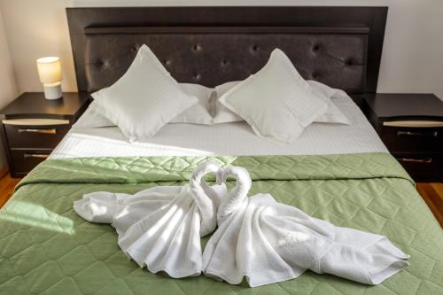 two white swans towels are sitting on a bed at Apartament Family Rivulus 10 in Baia Mare