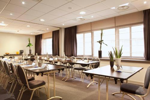a conference room with tables and chairs and windows at Escale Oceania Quimper Centre in Quimper