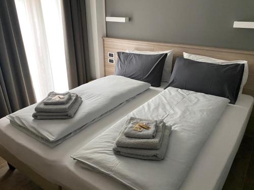 - un lit blanc avec serviettes de toilette dans l'établissement B&B A fil di cielo, à Val Masino