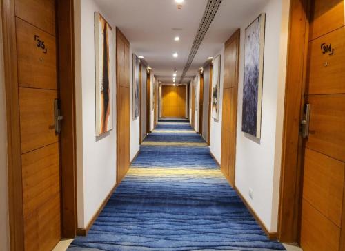a hallway in a building with a blue carpet at Best Western Plus Tejvivaan in Visakhapatnam