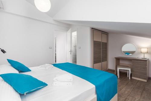 a white and blue bedroom with a bed and a desk at Villa Ancora in Rovinj