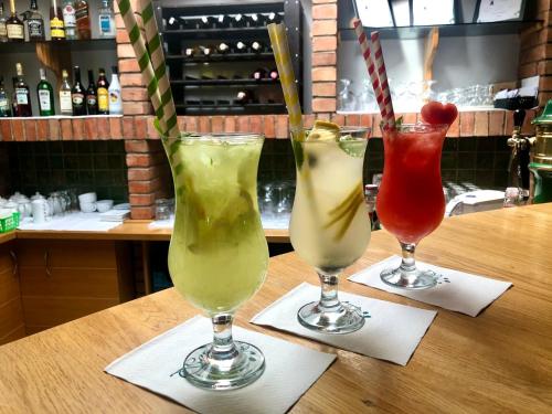 three cocktails in glasses sitting on a table at Sosnowe Zacisze in Białystok
