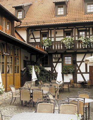 a group of tables and chairs in front of a building at Hotel Goldener Hirsch in Suhl