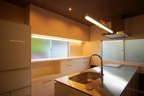 uma cozinha com um lavatório e uma janela em Famille Ōmuro em Ito