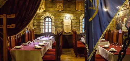 una sala da pranzo con tavoli e sedie e una sala con di Hotel Fortetsya Hetmana a Hatne