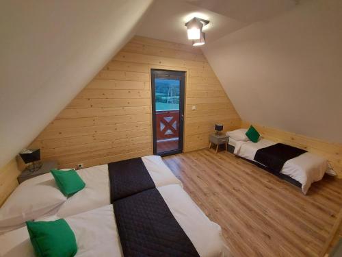 een slaapkamer met 2 bedden op een zolder bij Osada Orlica 1 in Lasowka