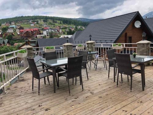 a deck with tables and chairs on top of a house at Hotel Kalyna in Bukovel
