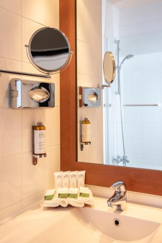 a bathroom with a sink and a mirror at Best Western Plus Hôtel Colbert in Châteauroux