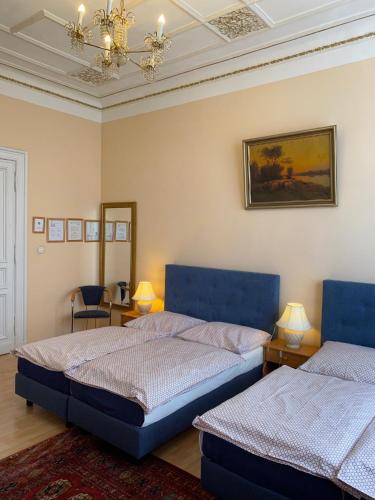 a bedroom with two beds and a chandelier at Hotel Gunia in Berlin