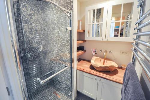 ein Bad mit einer Dusche und einem Waschbecken in der Unterkunft Beverly house in Knokke-Heist