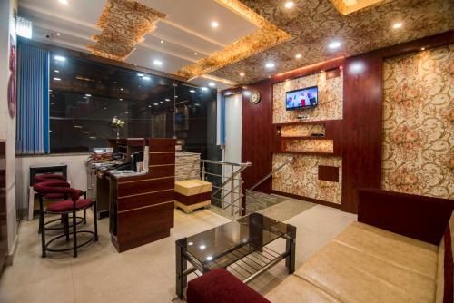 a lobby with a bar with a tv on the wall at Hotel Bleue Mont in Varanasi