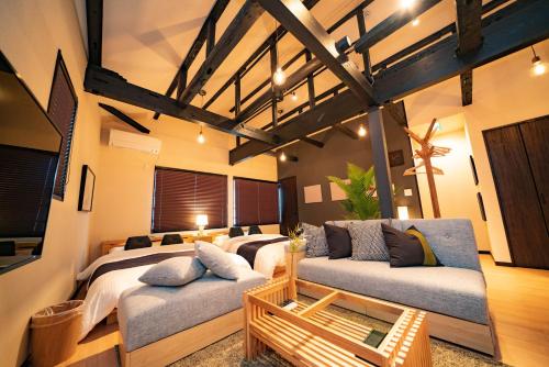 a room with three beds and a couch in it at EAST ONE Higashishinjuku in Tokyo
