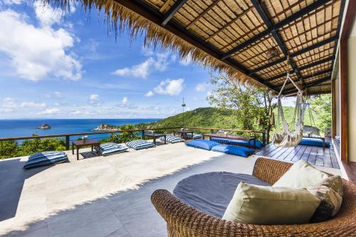 un patio al aire libre con sillas y vistas al océano en Baan Talay Resort & Yoga en Ko Tao