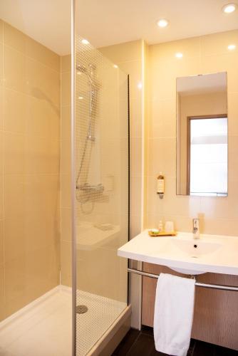 a bathroom with a shower and a sink at Best Western Plus Hôtel Colbert in Châteauroux