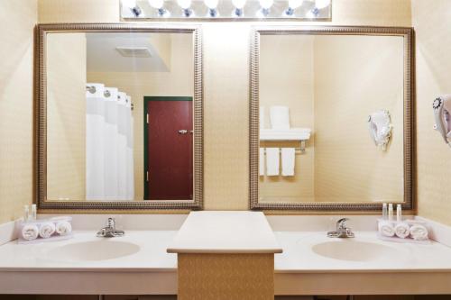 ein Badezimmer mit zwei Waschbecken und zwei Spiegeln in der Unterkunft Holiday Inn Express Durham-UNH, an IHG Hotel in Durham