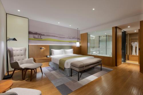 a bedroom with a bed and a desk and a chair at Holiday Inn & Suites Tianjin Downtown, an IHG Hotel in Tianjin