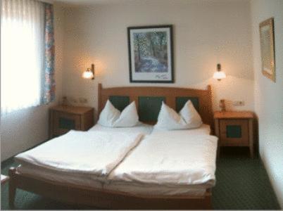 a bedroom with a bed with white sheets and pillows at Landgasthof zur Brücke in Wiesentheid