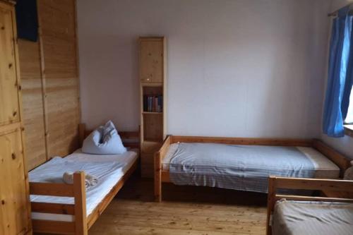 a bedroom with two beds and a book shelf at 2 Ferienhaus Andermichlhof in Geltendorf