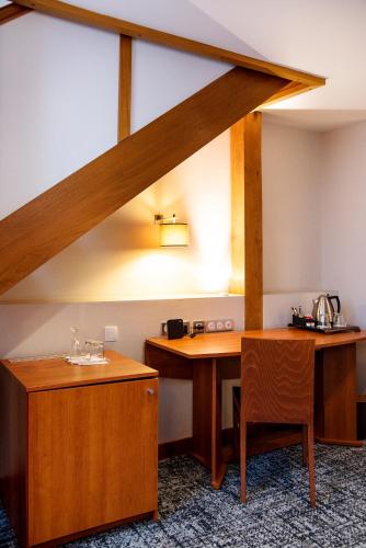 a room with a wooden table and a chair at Best Western Plus Hôtel Colbert in Châteauroux