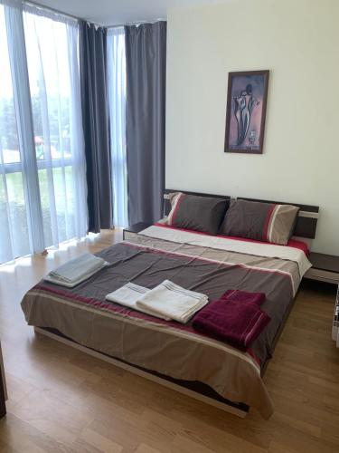 a bedroom with a large bed with towels on it at Marina Holiday Club&SPA Apartment in Pomorie