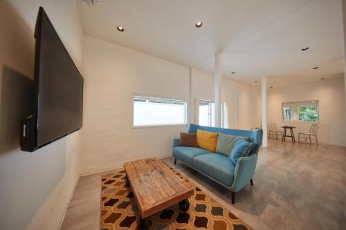 a living room with a blue couch and a table at ADAN RESORT 縁 - En - in Motobu